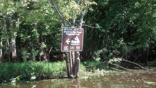 Image of a brown canoe sign on a tree