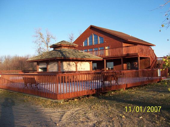 Image from back of two story wooden house with deck